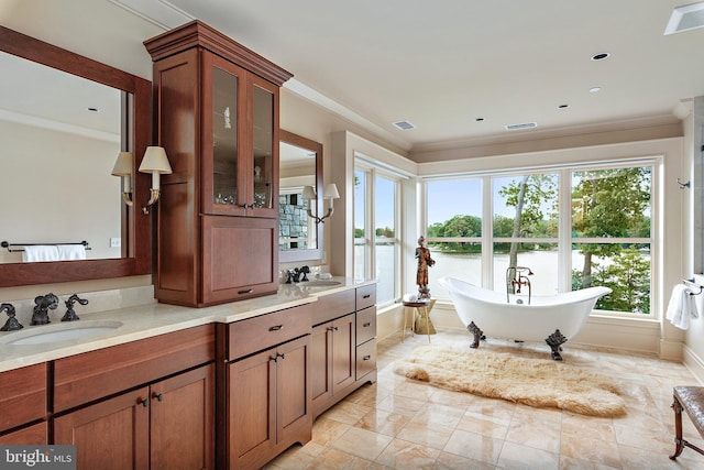 bathroom with vanity, a bathtub, and ornamental molding