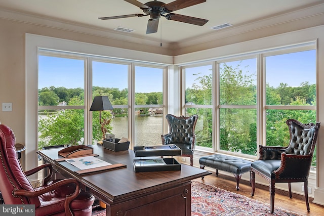 home office featuring a water view, ceiling fan, hardwood / wood-style flooring, and crown molding