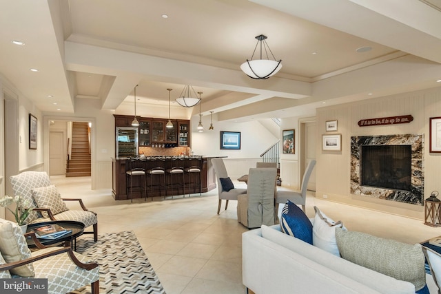 tiled living room featuring a tray ceiling, crown molding, and a high end fireplace