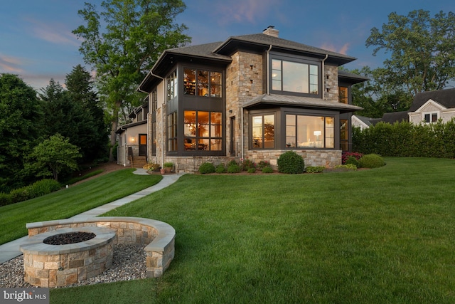 view of front of house with a fire pit and a yard