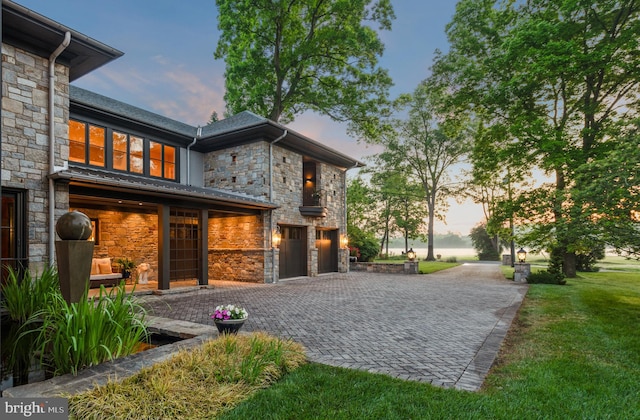 property exterior at dusk featuring a yard