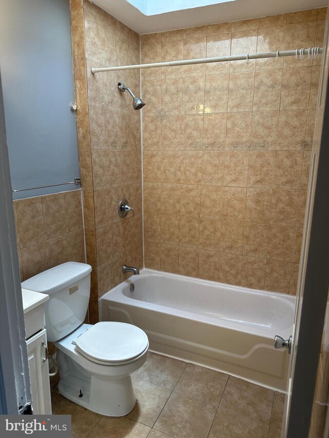 full bathroom featuring vanity, tile walls, toilet, tile patterned floors, and tiled shower / bath combo