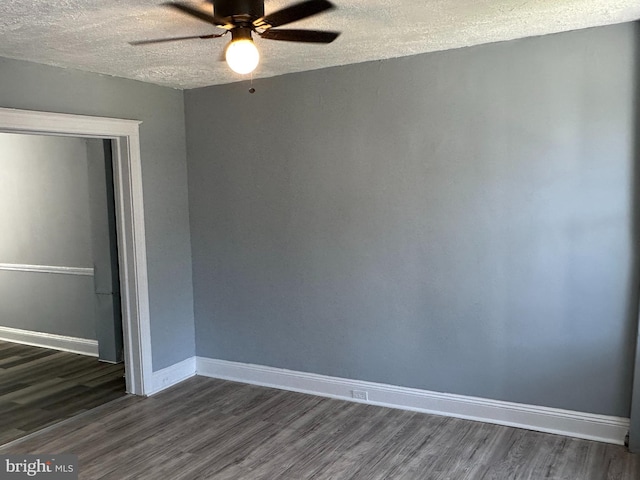 unfurnished room featuring ceiling fan, dark hardwood / wood-style flooring, and a textured ceiling