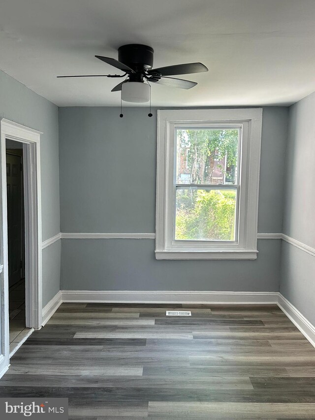 empty room featuring dark wood-type flooring and ceiling fan