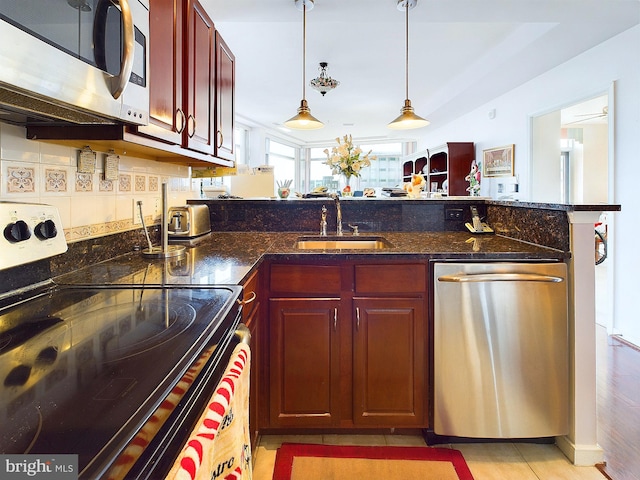 kitchen with light hardwood / wood-style flooring, appliances with stainless steel finishes, sink, pendant lighting, and tasteful backsplash