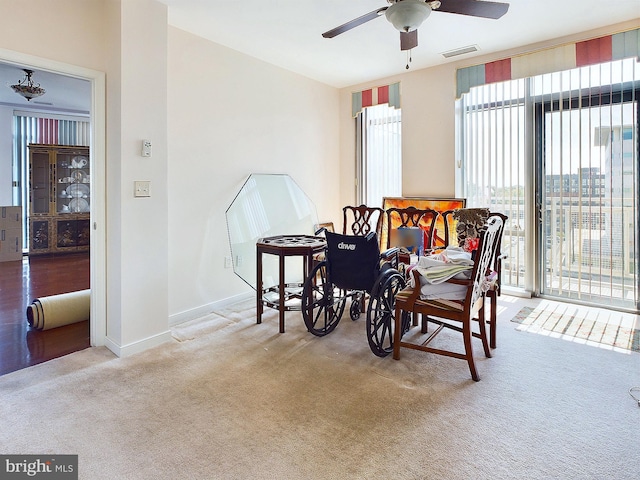 dining room with ceiling fan and light carpet