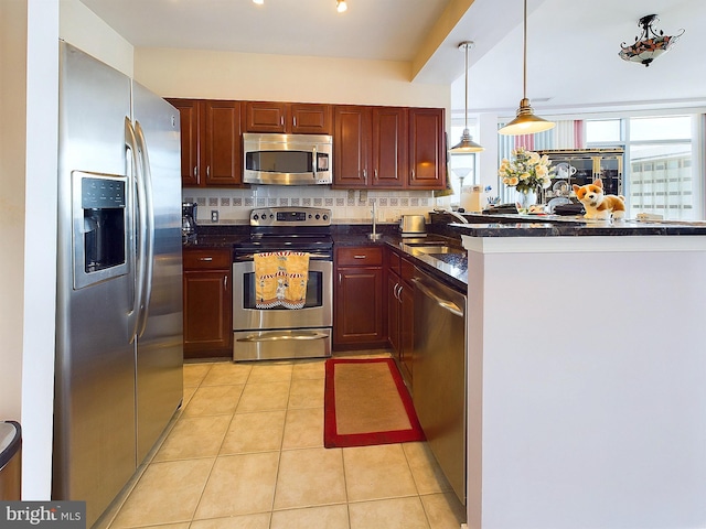 kitchen with decorative light fixtures, stainless steel appliances, kitchen peninsula, light tile patterned flooring, and decorative backsplash