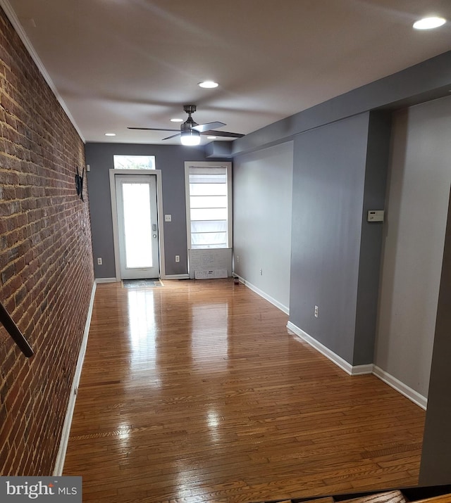 spare room with ceiling fan, brick wall, and hardwood / wood-style floors