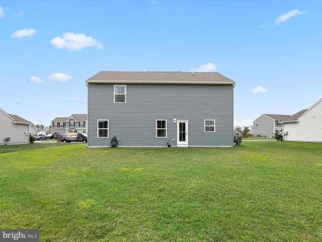 back of house with a yard and central AC