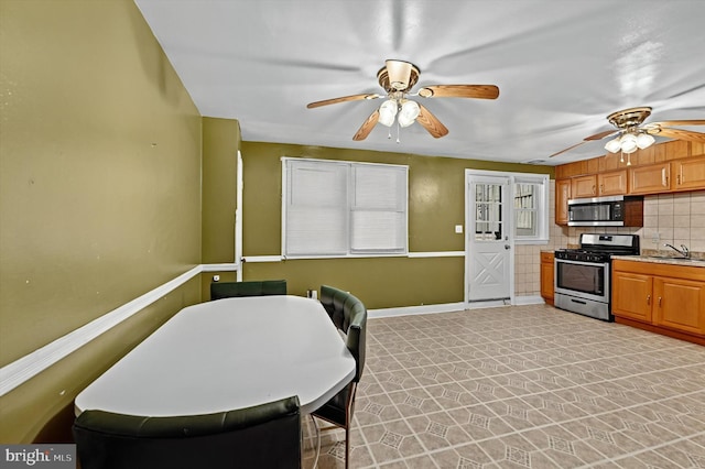 kitchen with tasteful backsplash, ceiling fan, sink, and stainless steel appliances