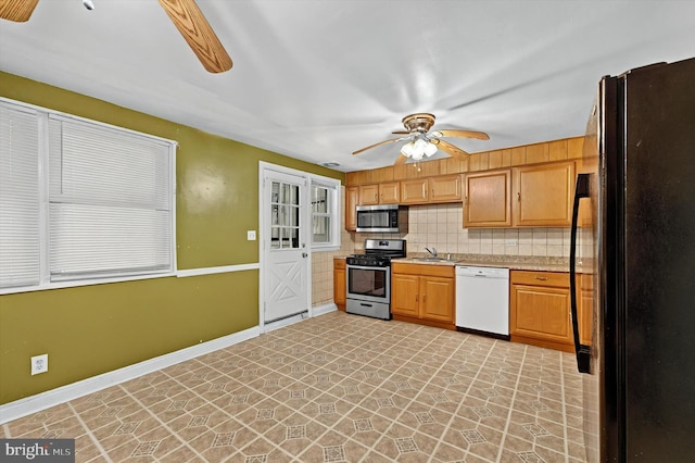 kitchen with backsplash, stainless steel appliances, ceiling fan, and sink