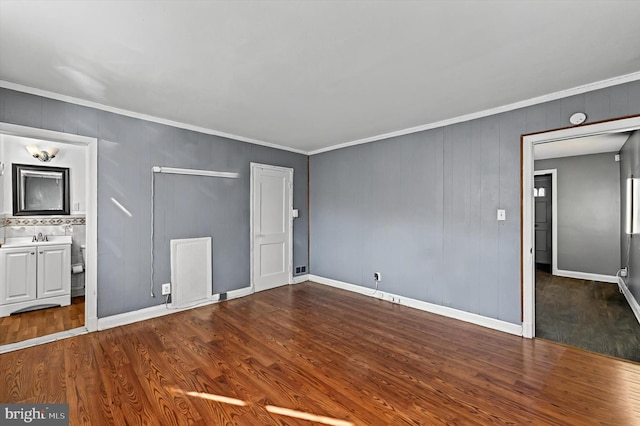 unfurnished room featuring crown molding, sink, and wood-type flooring