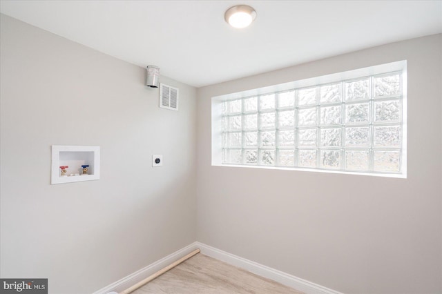 clothes washing area with washer hookup, a wealth of natural light, hookup for an electric dryer, and light hardwood / wood-style flooring