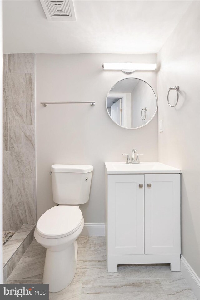 bathroom with walk in shower, vanity, and toilet