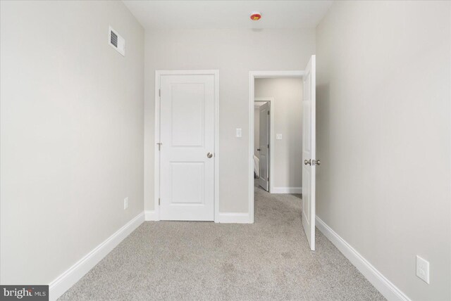 unfurnished bedroom with light colored carpet