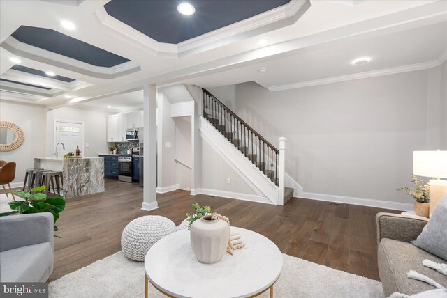 living room with coffered ceiling, ornamental molding, beam ceiling, and dark wood-type flooring