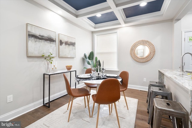 dining room with beamed ceiling, sink, dark wood-type flooring, coffered ceiling, and crown molding