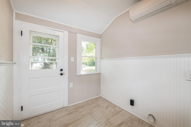 entryway featuring a wall mounted AC and vaulted ceiling