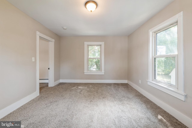 carpeted spare room with a baseboard radiator