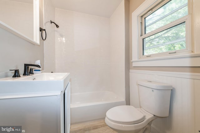 full bathroom with wood-type flooring, toilet, tiled shower / bath combo, and vanity