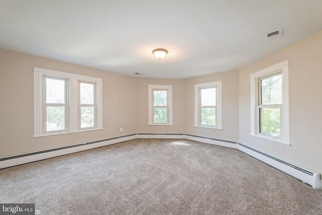 carpeted empty room featuring a baseboard heating unit