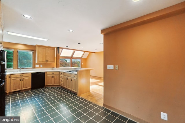 kitchen featuring light brown cabinetry, sink, a skylight, dishwasher, and dark tile patterned floors