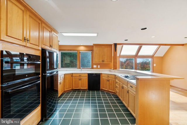 kitchen featuring dark tile patterned floors, sink, black appliances, and kitchen peninsula