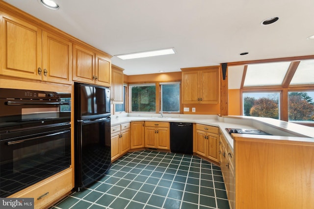 kitchen with sink, black appliances, and kitchen peninsula