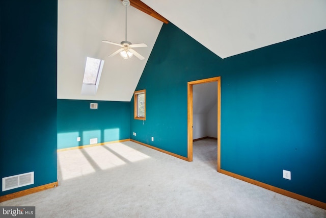 unfurnished living room featuring lofted ceiling with skylight, carpet, and ceiling fan