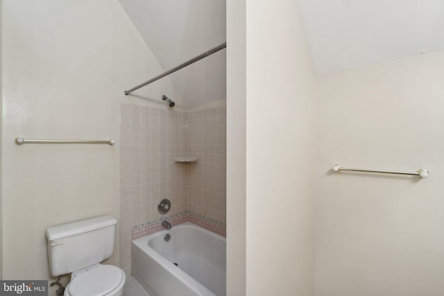 bathroom featuring lofted ceiling, tiled shower / bath combo, and toilet