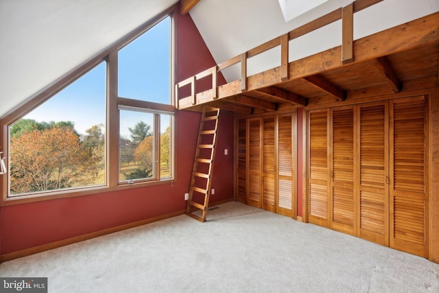 additional living space with lofted ceiling with beams and carpet flooring