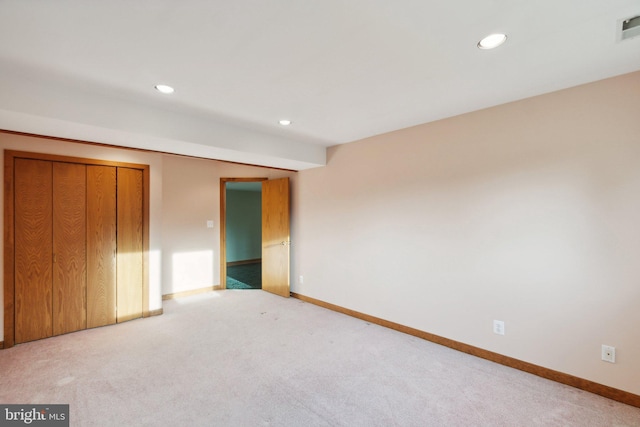 unfurnished bedroom featuring a closet and light colored carpet