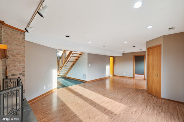 unfurnished living room with a brick fireplace and hardwood / wood-style flooring