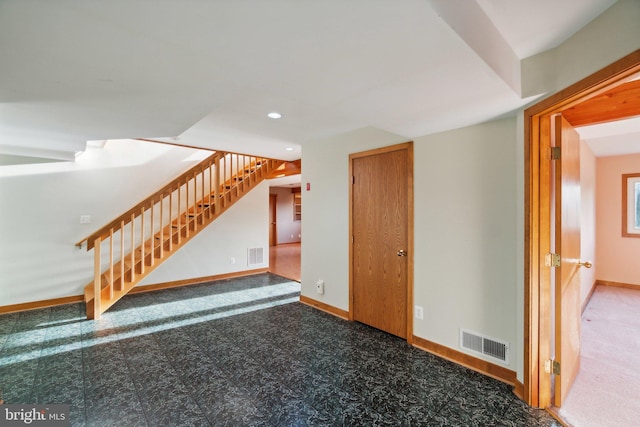 unfurnished living room with dark colored carpet