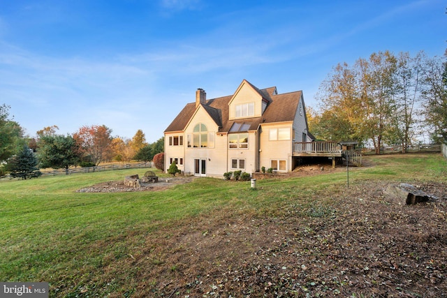 rear view of house featuring a yard and a deck