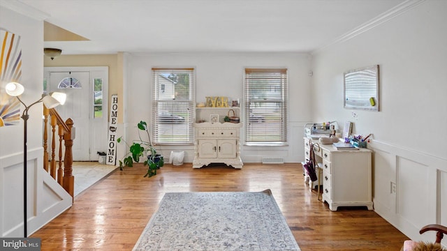 entryway featuring ornamental molding and light wood-type flooring