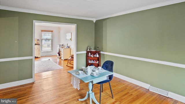 interior space featuring crown molding and light hardwood / wood-style flooring