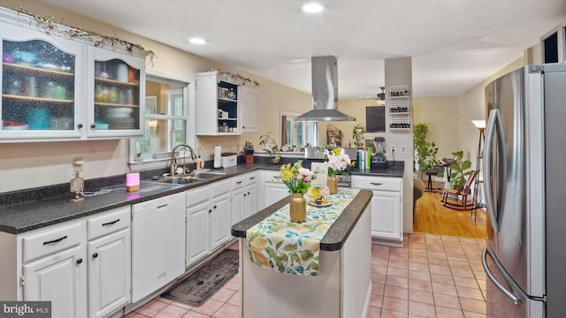 kitchen featuring white cabinets, dishwasher, and stainless steel fridge