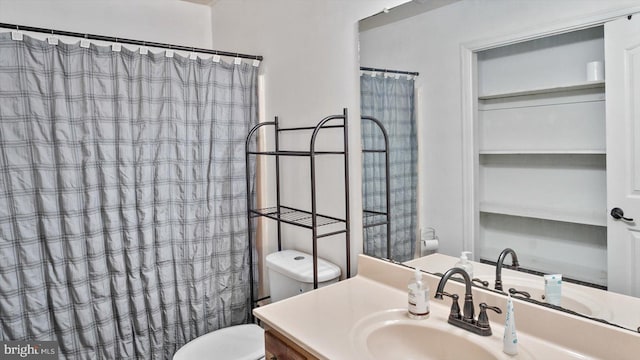 bathroom with walk in shower, vanity, and toilet