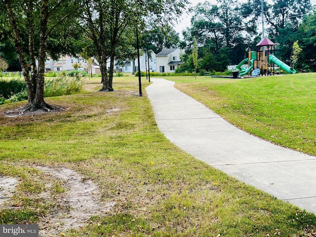 view of property's community featuring a lawn and a playground