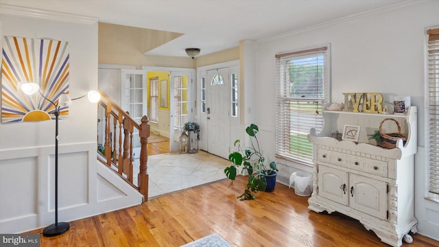 entrance foyer featuring ornamental molding and hardwood / wood-style floors