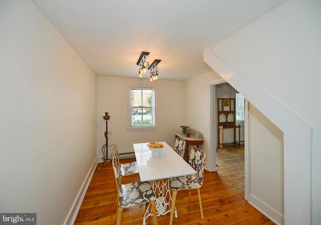 dining area with baseboard heating and dark hardwood / wood-style flooring