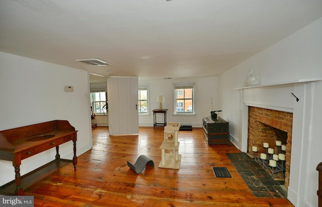 exercise area with dark wood-type flooring and a fireplace