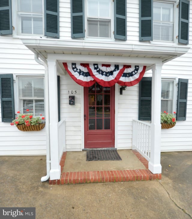 view of exterior entry featuring covered porch