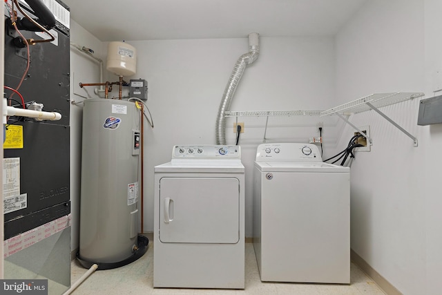 clothes washing area featuring heating unit, water heater, and washer and dryer