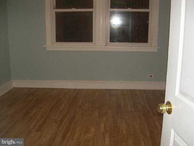 empty room with dark hardwood / wood-style flooring