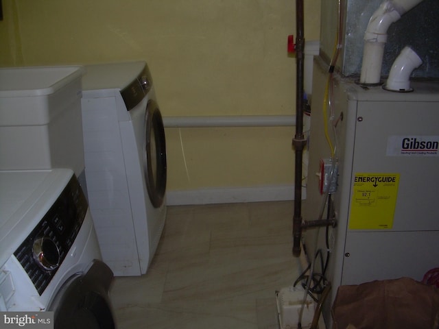 washroom featuring heating unit and washing machine and clothes dryer