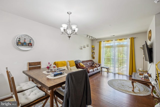 dining room with dark hardwood / wood-style flooring and a notable chandelier