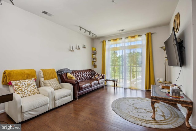 living room with dark hardwood / wood-style floors and track lighting