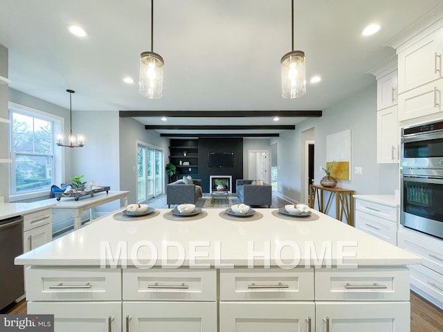 kitchen with white cabinetry, hanging light fixtures, and appliances with stainless steel finishes